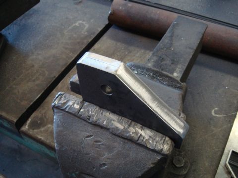 1996 Ford Bronco - A metal bracket is secured in a vise, ready for work.