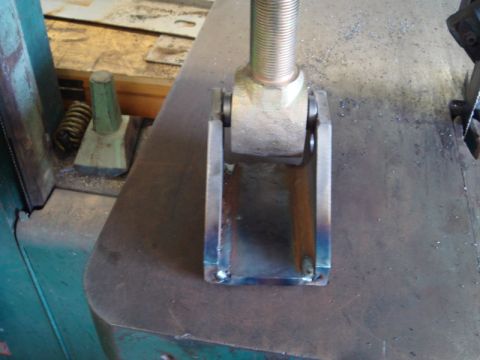 1996 Ford Bronco - A close-up view of a metal bracket with a bolt, likely a component from a larger assembly.