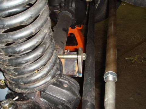 1996 Ford Bronco - Vehicle suspension components are visible, including a large coil spring and an orange jack supporting the frame.