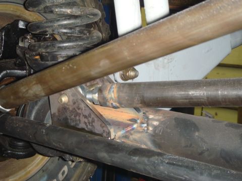 1996 Ford Bronco - Detail of a vehicle's suspension system, showing various metal components and a coil spring.