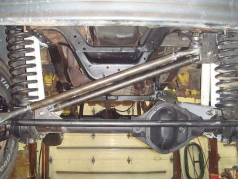 1996 Ford Bronco - Undercarriage view reveals aftermarket steering and suspension modifications on a lifted vehicle.