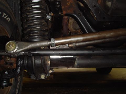 1996 Ford Bronco - Underside view of a vehicle's steering and suspension system, highlighting the tie rod ends and coil spring assembly.