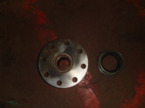 1996 Ford Bronco - A metal wheel hub and a rubber seal are shown on a dark red, textured surface.