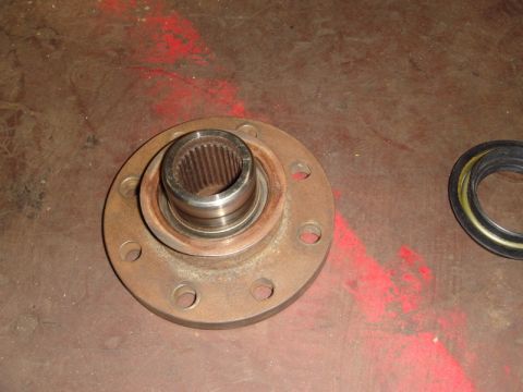 1996 Ford Bronco - A vehicle wheel hub assembly and a seal are shown on a workbench.