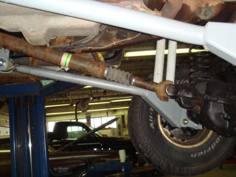 1996 Ford Bronco - Close-up of vehicle undercarriage components, with another vehicle in the background.
