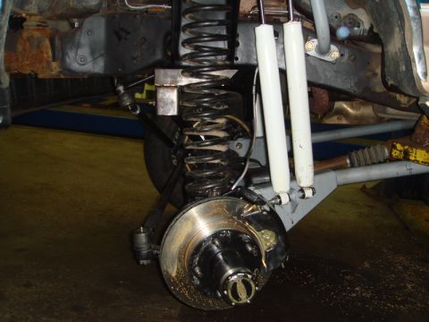 1996 Ford Bronco - Front suspension and brake assembly detail, showing coil spring, shock, and rotor.