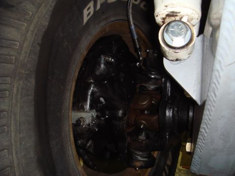 1996 Ford Bronco - Detail shot of the front suspension and tire assembly on a vehicle.