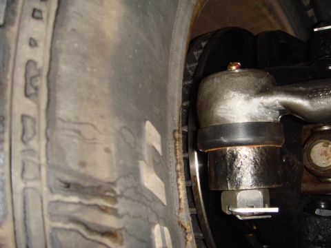 1996 Ford Bronco - Close-up view of a vehicle's tie rod end assembly, showing mechanical components near the tire.