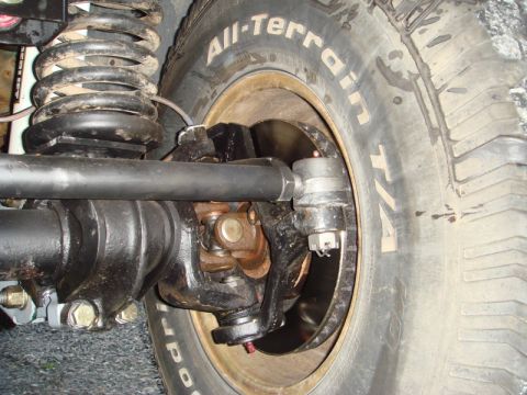 1996 Ford Bronco - Detail of the suspension system and tire on a vehicle, showing mechanical components.