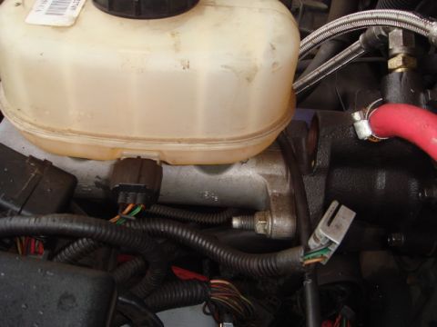 1996 Ford Bronco - Close-up view of engine components including the brake fluid reservoir and master cylinder.