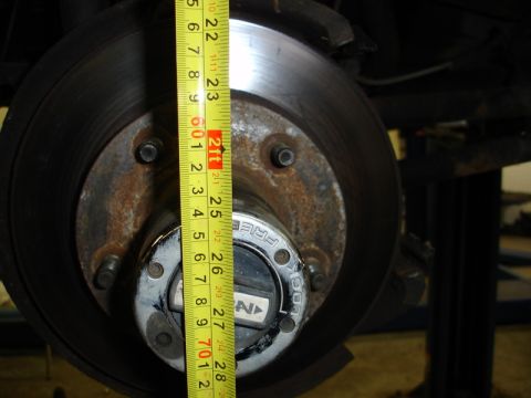 1996 Ford Bronco - A measuring tape is used to check the size of a vehicle's hub and rotor assembly.