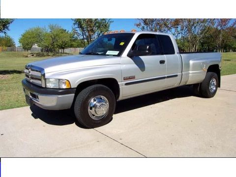 1986 Ford Bronco - 1994 Dodge Ram 3500 dually pickup truck with a chrome grille and wheels.