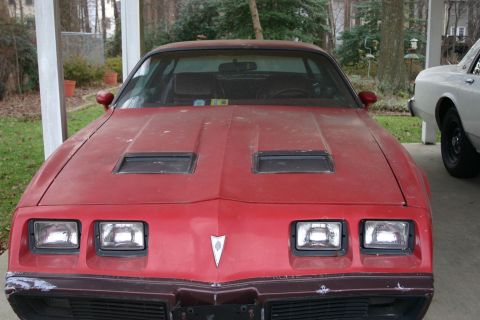 1993 Ford Bronco - Front view of a red 1977 Pontiac Firebird, distinctive hood scoops and dual square headlights.