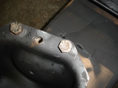 1996 Ford Bronco - A metal bracket with two hex bolts is shown, with one bolt clearly displaying the imprint '19'.