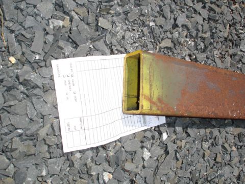 1996 Ford Bronco - A close-up of a rusty metal pipe and a receipt lying on a bed of gravel.