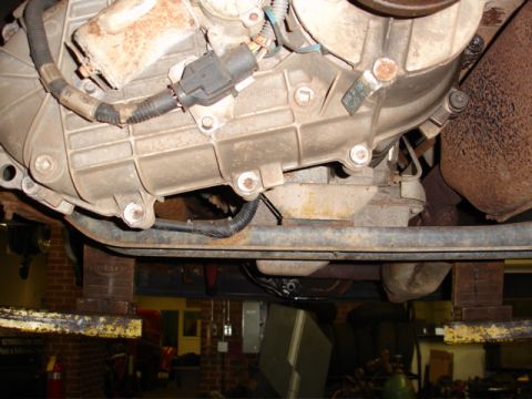 1996 Ford Bronco - Underside view of vehicle mechanical components, including transmission and exhaust system, on a lift.