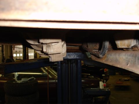 1996 Ford Bronco - Vehicle chassis and drivetrain components visible while on a repair lift.