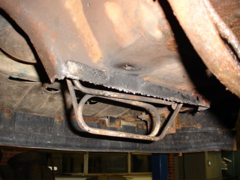 1996 Ford Bronco - The underside of a vehicle shows significant rust and exposed fuel lines.