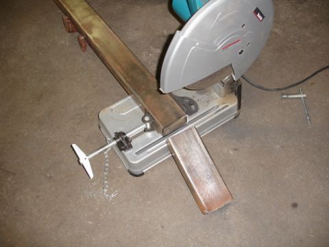 1996 Ford Bronco - A metal cutting saw is positioned to cut a steel beam, with another cut piece resting nearby.