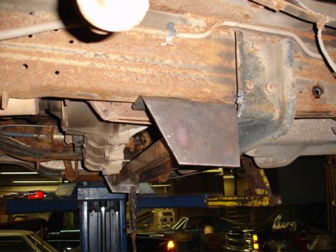 1996 Ford Bronco - A custom metal bracket is welded to the frame of a vehicle, visible near the transmission.