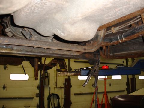 1996 Ford Bronco - Underside view of a vehicle in a garage, showing suspension and fuel tank components.