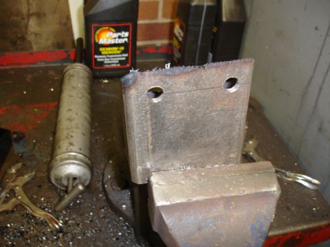 1996 Ford Bronco - A metal bracket is secured in a vise, ready for work, with automotive fluids in the background.