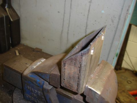 1996 Ford Bronco - A fabricated metal bracket is secured in a vise, ready for further work.