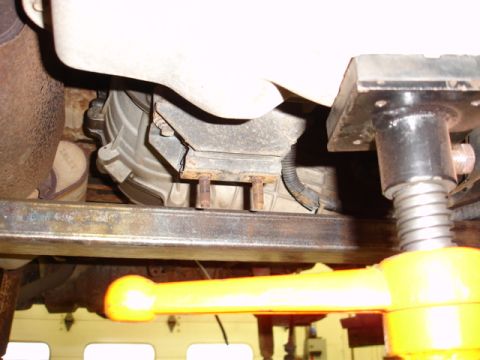 1996 Ford Bronco - Vehicle transmission mount detail, showing bolts and a wiring harness attached.