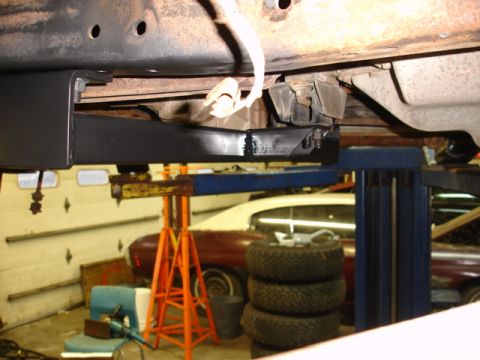 1996 Ford Bronco - A black metal bracket is installed on the underbody of a vehicle, with other vehicles visible in the background.