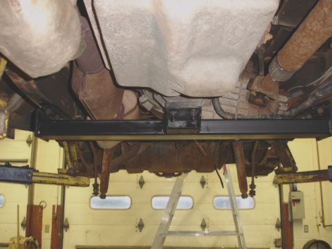 1996 Ford Bronco - The undercarriage of a vehicle is shown, with a focus on the newly installed hitch receiver and suspension components.