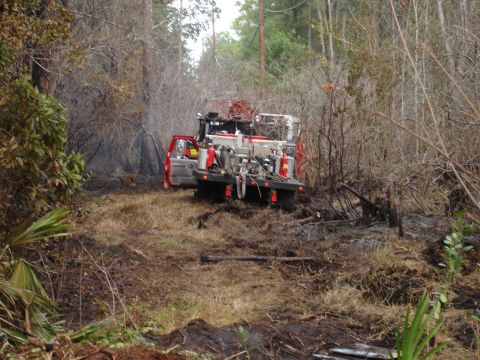 1989 Ford Bronco - Fire truck is parked off-road in a dry, wooded area.