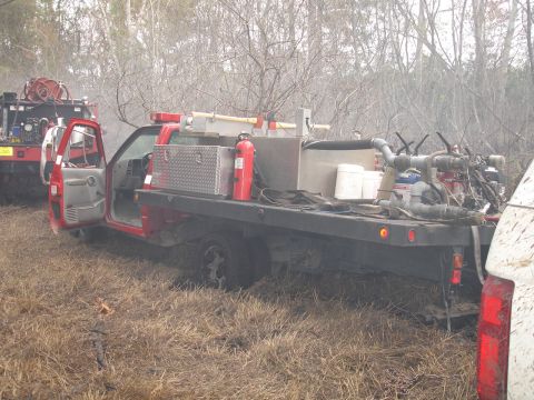 1989 Ford Bronco - A modified truck equipped for firefighting operations sits in a grassy, wooded area.