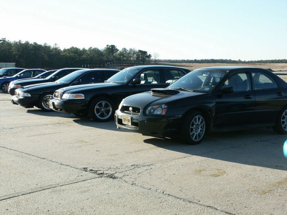 Black 2001 Mercury Grand Marquis parked in a line of cars, front 3/4 view