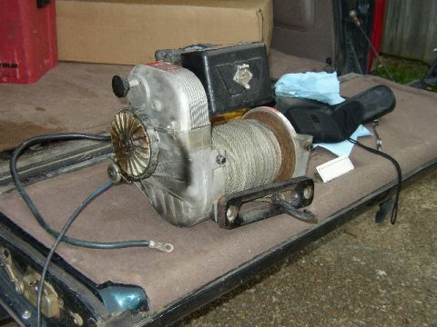 1995 Ford Bronco - An electric winch is shown with its cable wound around the spool and electrical wires attached.