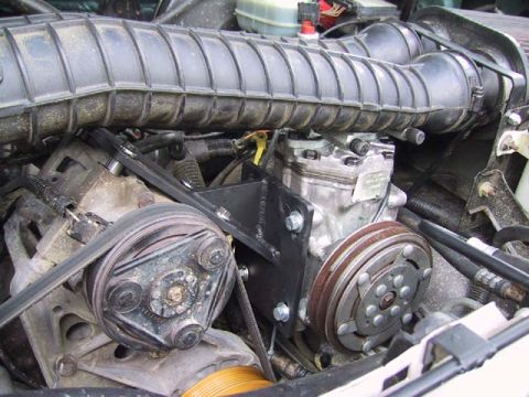 1995 Ford Bronco - Close-up view of engine components including the air intake and compressor assembly.