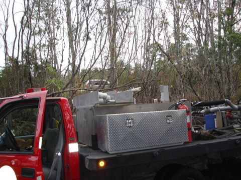 1989 Ford Bronco - A red truck is outfitted with a water tank and equipment, possibly for firefighting or landscape work.
