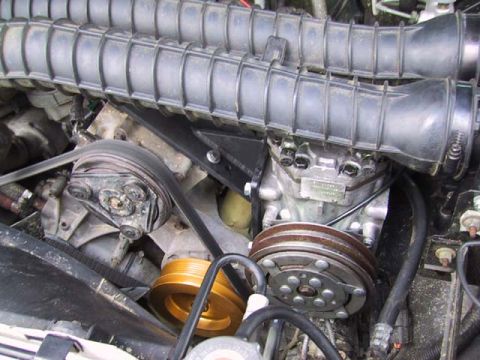 1995 Ford Bronco - Engine bay components including air intake hoses, belts, and pulleys are visible in this close-up shot.