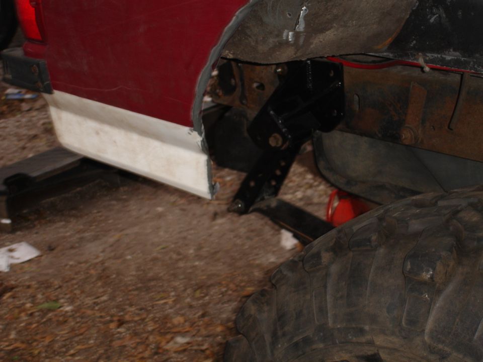 Close-up of vehicle frame and fender area with visible suspension components and large tire