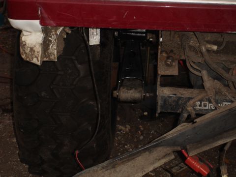 1989 Ford Bronco - This image shows a close-up view of a vehicle's rear tire and suspension system, with visible wiring and metal parts.