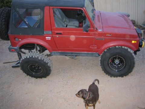 1987 Suzuki Samurai - A red 1987 Suzuki Samurai is shown with modifications for off-road use.