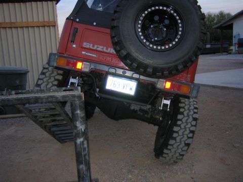1987 Suzuki Samurai - Suzuki Samurai rear view, tilted on an obstacle with its license plate visible.