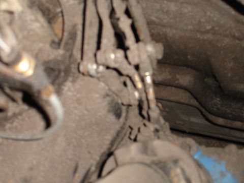 1989 Ford Bronco - Close-up view of brake and fuel lines underneath a vehicle.