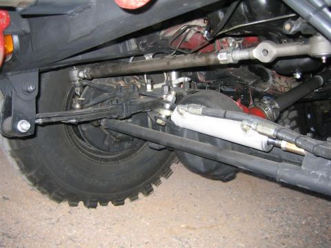 1987 Suzuki Samurai - Undercarriage view of a vehicle's steering and suspension system, including leaf springs and a shock absorber.