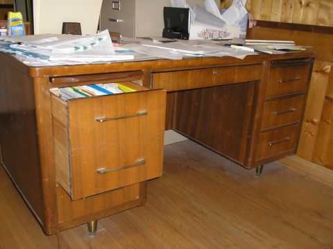 1990 Ford Bronco - A cluttered wooden desk with files and papers, suggesting an office environment.
