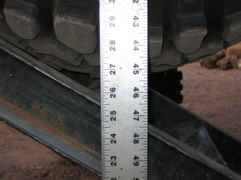 1987 Suzuki Samurai - Measuring clearance with a ruler against a tire and suspension part.