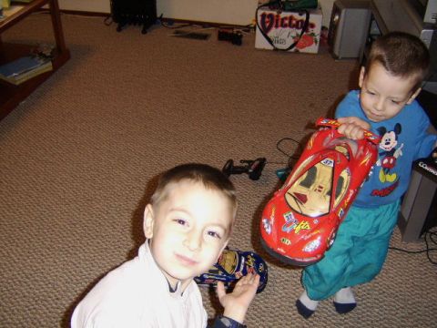 1989 Ford Bronco - Two children are playing with toy cars indoors on a carpeted floor.