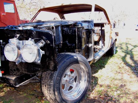 1964 Mercury Comet - This car is in a state of disassembly, with its engine bay empty and body panels removed.