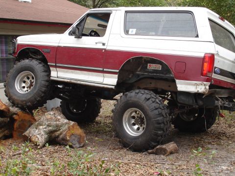 1989 Ford Bronco - This lifted 1989 Ford Bronco is shown with its large off-road tires positioned on logs.