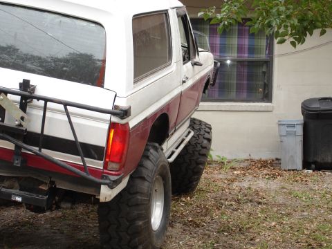 1989 Ford Bronco - This modified Ford Bronco sits high on large off-road tires, showing its rear end.