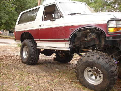 1989 Ford Bronco - This lifted SUV features a two-tone paint scheme and aggressive off-road tires, indicative of a 1987 model year.